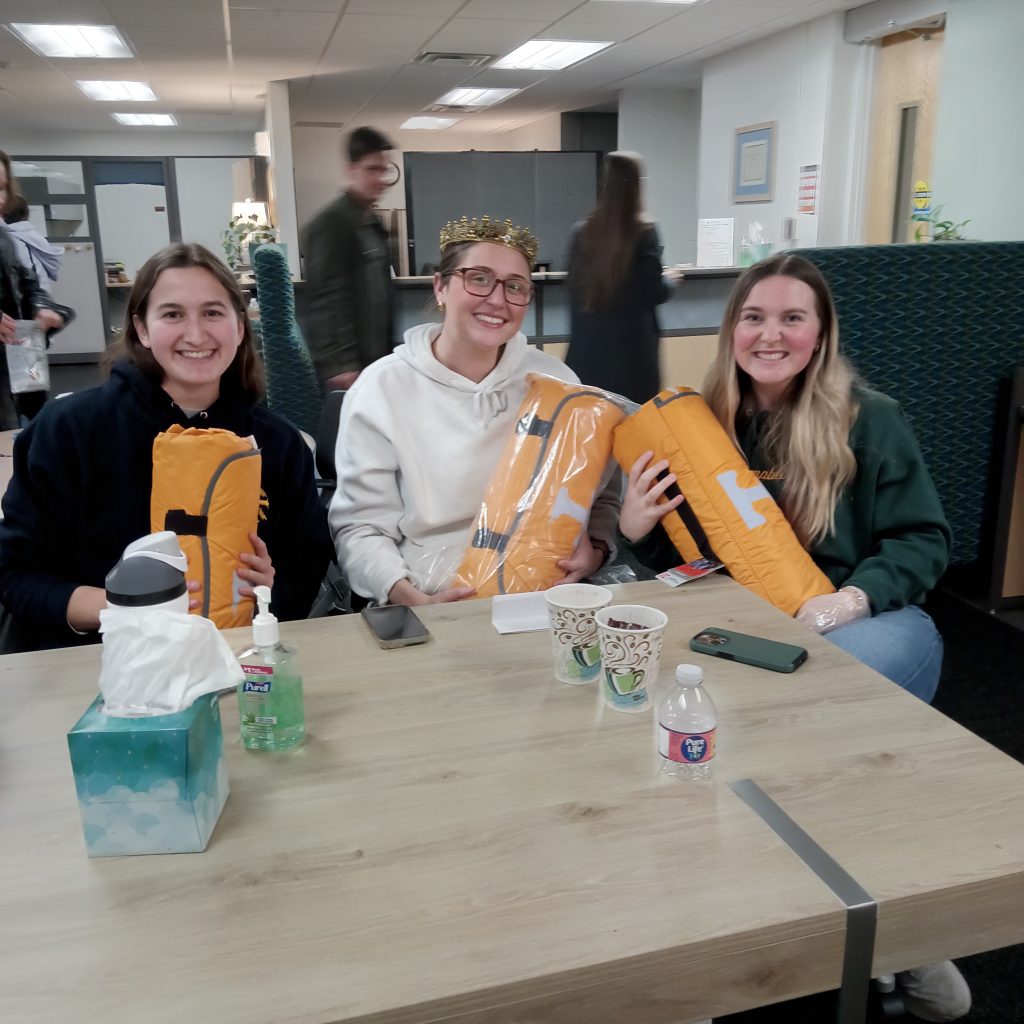 Three winners hold UT blankets.